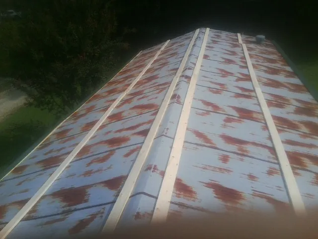 Rusted metal roof panels with new wood purlins before replacement — Storm Damage Roof Repair in Opelika by Roofing Brothers