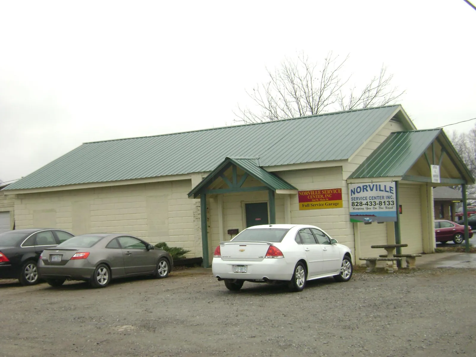 Green metal roof on a service garage with a covered entry in Opelika