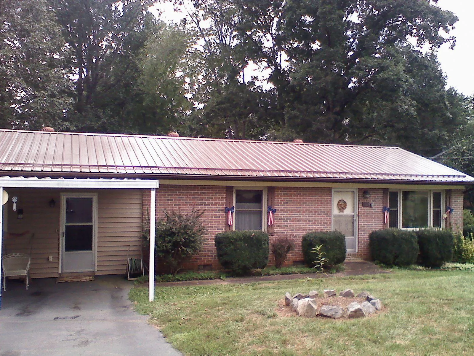Bronze metal roof and carport on a brick ranch home — Roof Repair work by our crew in Opelika