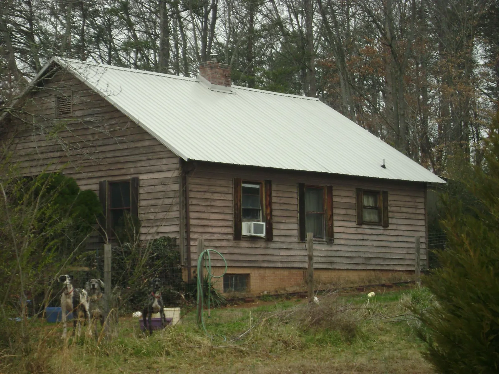 White metal roof on an old wood sided farmhouse, from a Metal Roof Installation job in Opelika
